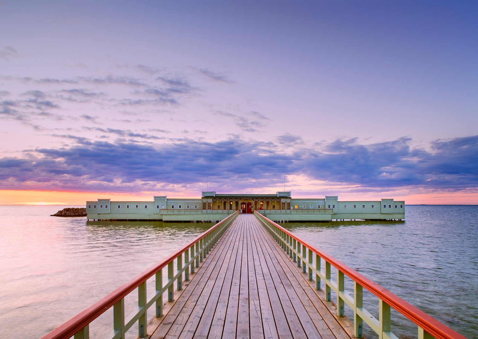 Ribersborgs kallbadhus En vy över Ribersborgs Kallbadhus och dess brygga. Vacker solnedgång i bakgrunden.
